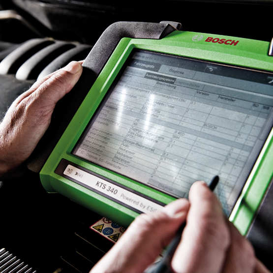 Werkstattfoto: Mitarbeiter bedient digitales Prüfgerät